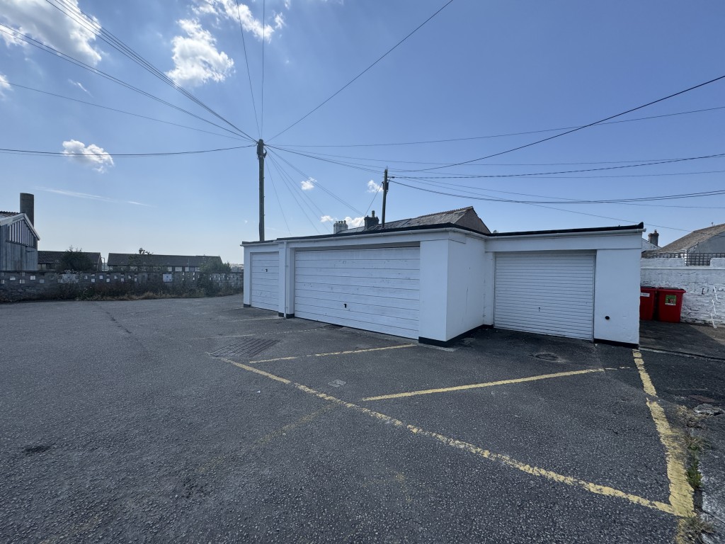 Lot: 65 - TWO STOREY COMMERCIAL UNIT WITH POTENTIAL, DETACHED BLOCK OF FOUR GARAGES AND CAR PARK - View of garages with parking